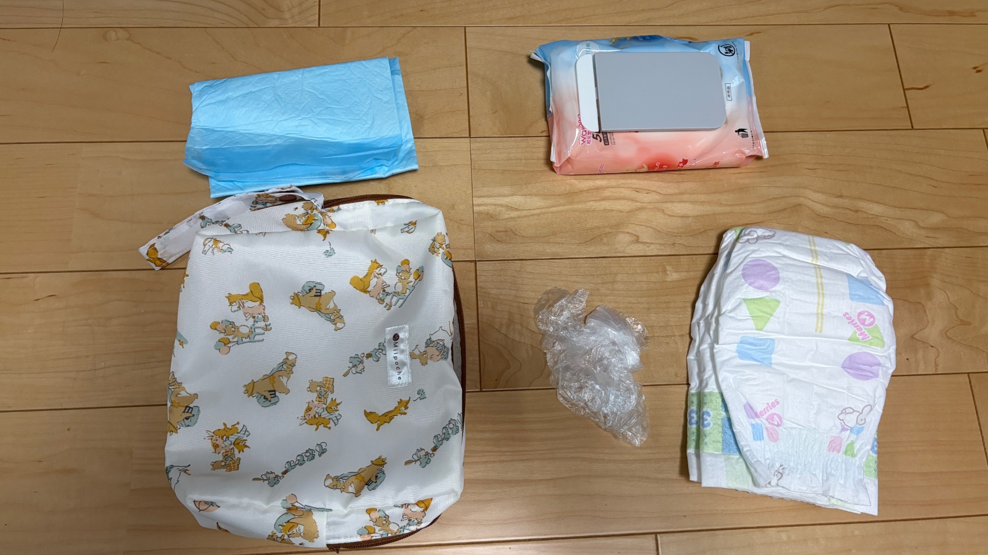 おむつポーチの中身。ポーチ、ペットシート、おむつ、おしりふき、おむつを入れる袋